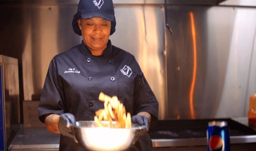 A chef mixing french fries in bowl